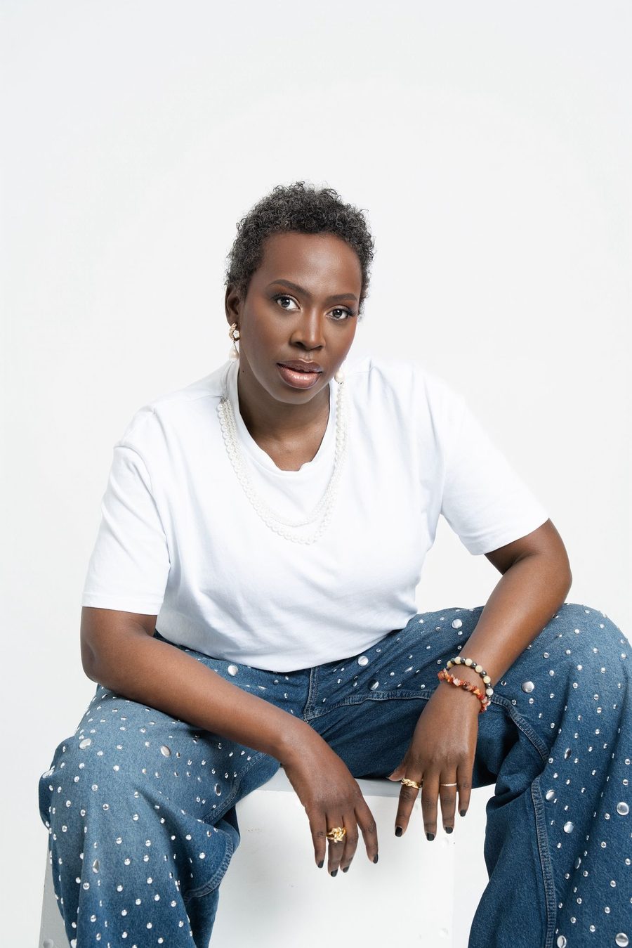 Nadège Mongerard, assise, t-shirt blanc et jean, regard vers l’objectif.